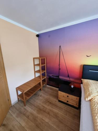 una camera da letto con un dipinto di una barca a vela sul muro di 80 m2, für bis 6 Personen mit tollem Skigebiet, zentral und doch ruhig a Waidring