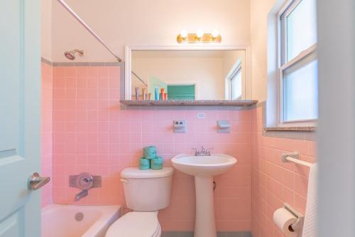 a pink bathroom with a sink and a toilet at Tropical Breeze in Clearwater Beach