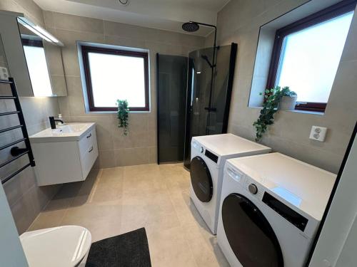 een badkamer met een wasmachine en een wastafel bij Lägenheter Vallersgatan in Visby