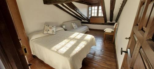 a bedroom with a bed in a room with wooden floors at Casa del Lavadero in Santillana del Mar