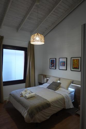 a bedroom with a large bed and a chandelier at Apartamento Casa Dalí in Jerez de la Frontera