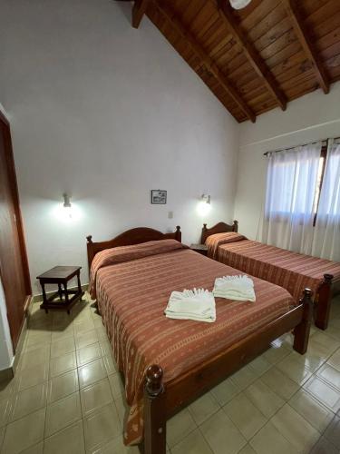 a bedroom with two beds with white towels on them at Hotel Garay in San Bernardo