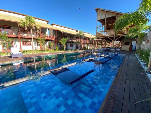 einen Pool in einem Resort mit Liegestühlen in der Unterkunft Pousada Encantos do Coqueiro in Luis Correia