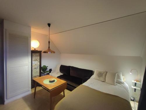 1 dormitorio con cama, sofá y mesa en Villaidyll i Svanesund nära havet en Svanesund