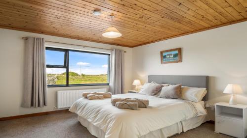 - une chambre avec un grand lit et une fenêtre dans l'établissement Little Tara, Ballyconneely, à Ballyconneely