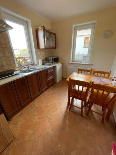 a kitchen with a wooden table and a table and chairs at Willa Kinga in Władysławowo