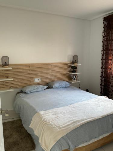 een slaapkamer met een groot bed met een houten hoofdeinde bij Villa Molle Mar Menor Golf resort in Torre-Pacheco