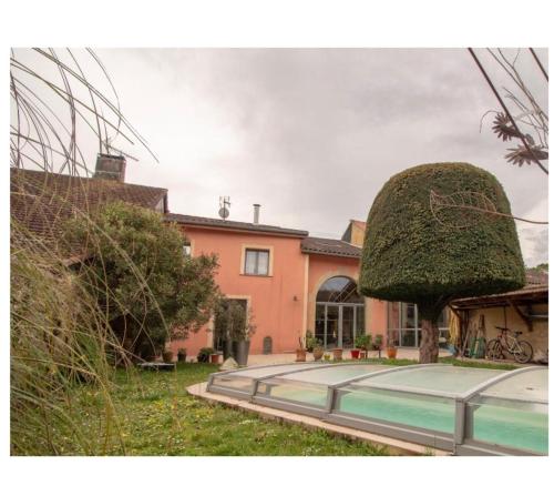 a house with a large round window in the yard at Maison avec piscine in Marciac