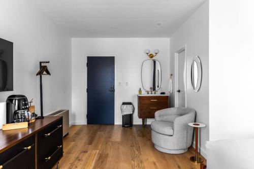 a living room with a chair and a mirror at Historic Hotel, Heart of Bangor, Fiber Wi-Fi, Roku TV, Room # 206 in Bangor