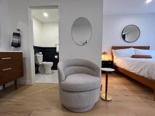 a bedroom with a bed and a chair next to a bed at Historic Hotel, Heart of Bangor, Fiber Wi-Fi, Roku TV, Room # 206 in Bangor