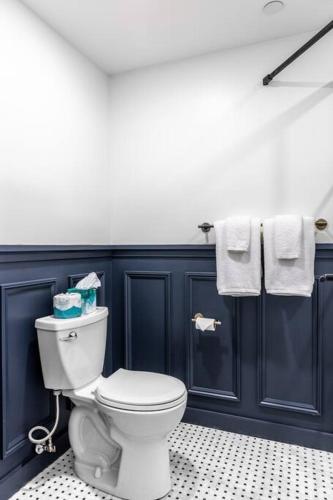 a bathroom with a toilet and blue walls and towels at Historic Hotel, Heart of Bangor, Fiber Wi-Fi, Roku TV, Room # 206 in Bangor