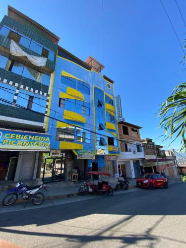 um edifício azul e amarelo no lado de uma rua em HOSPEDAJE Y TURISMO SOL & LUNA E.I.R.L em Tarapoto