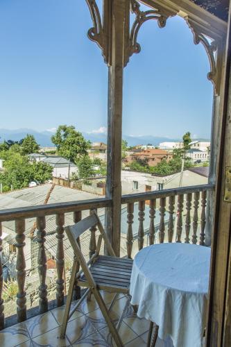 a wooden balcony with a table and a chair at Guest House Top Floor in Tʼelavi