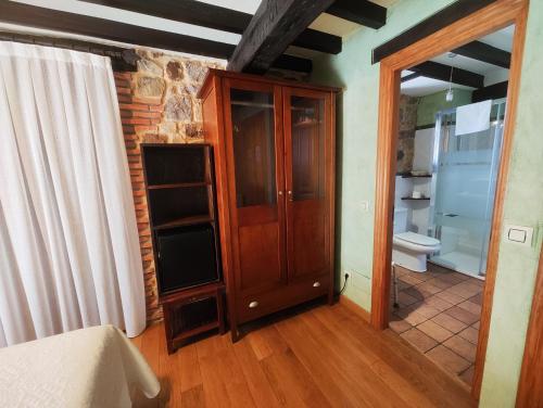 a room with a wooden cabinet and a toilet at Posada el Remanso de Trivieco in La Cavada