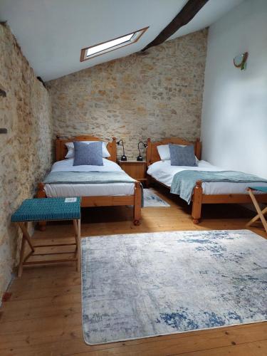 Habitación con 2 camas y alfombra. en B&B Franglaise, en Romagne