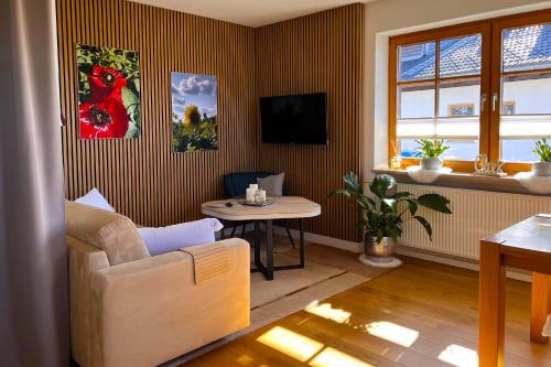 a living room with a couch and a table at Apartment Wohlfühlplatzl - urgemütlich & ruhig in Vogtareuth