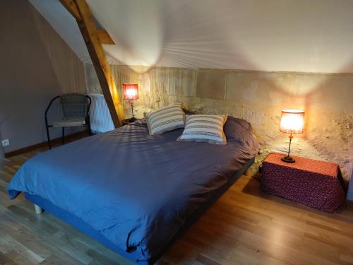 ein Bett mit zwei Kissen und zwei Lampen in einem Zimmer in der Unterkunft Maison au cœur des châteaux. in La Chapelle-aux-Naux