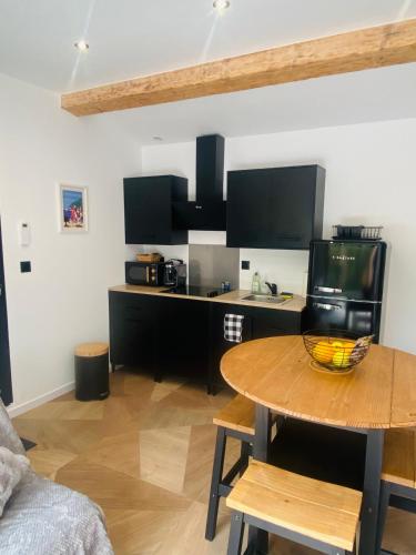 a living room with a table and a kitchen at Cosy Lodge Sainte Baume in Nans-les-Pins