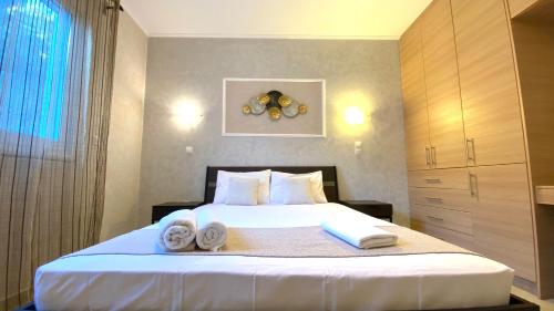 een slaapkamer met een bed met handdoeken erop bij Villa Christina Luxury in Vouliagmeni-meer