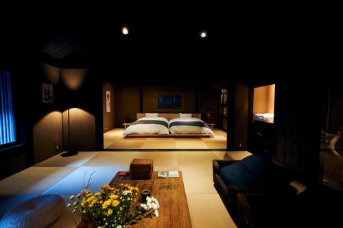 Yunotsuruにある湯の鶴迎賓館鶴の屋Tsurunoyaのベッドルーム1室(ベッド1台、ソファ、テーブル付)