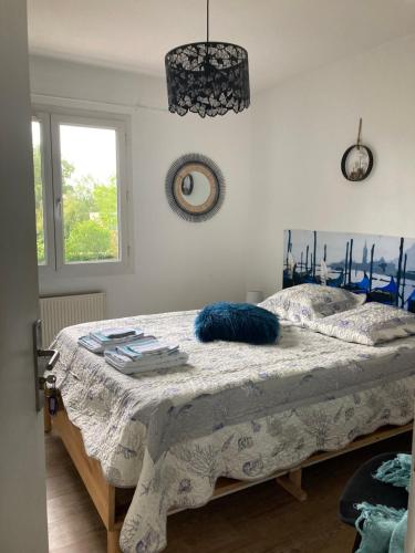 ein Schlafzimmer mit einem Bett mit blauen Kissen und einem Fenster in der Unterkunft Villa Rose Suite et chambres in Montpellier