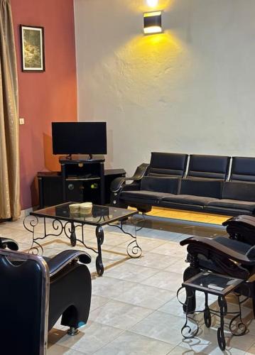 a living room with black furniture and a tv at KWEZI S Apartments in Bujumbura