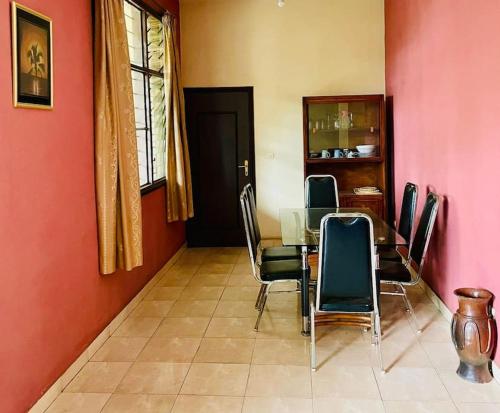 ein Esszimmer mit einem Tisch und Stühlen in der Unterkunft Oasis Urbaine 3 Chambres, Mixte in Bujumbura