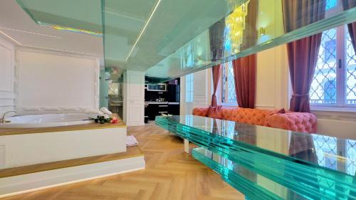 a large bathroom with a tub and a glass wall at Jacuzzi Opera Suite in Budapest