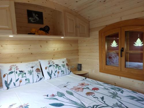 een bed in een houten kamer met een bed sidx sidx sidx bij Roulotte ZEN 