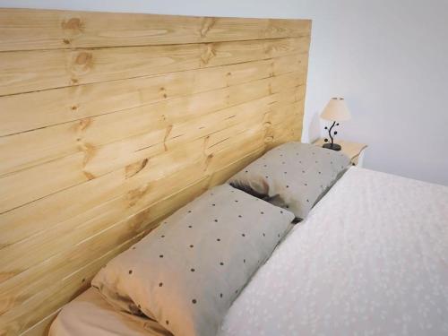 a bed with two pillows next to a wooden headboard at Casa terrera de 2 dormitorios en Fasnia in Fasnia