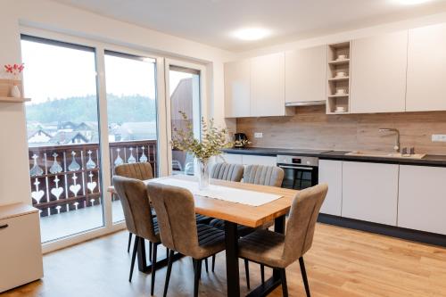 a kitchen with a table and chairs with a view at Apartments Naklo in Naklo