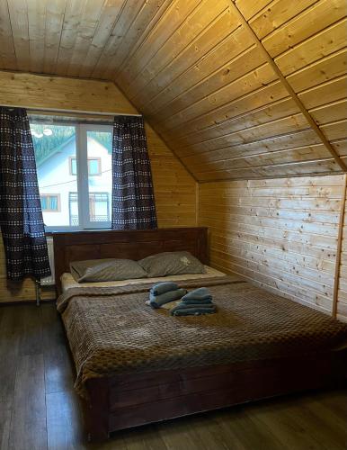 a bedroom with a bed in a wooden room at Khatky Na Penkakh in Vorokhta