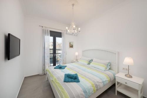 アギオス・ニコラオスにあるNikosの白いベッドルーム(ベッド1台、シャンデリア付)