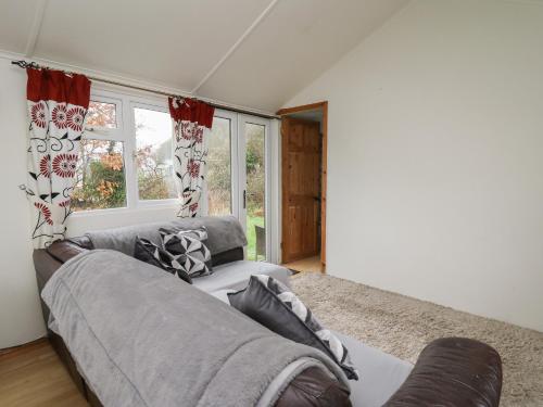 a living room with a couch and a window at Chalet 32 in Aberystwyth