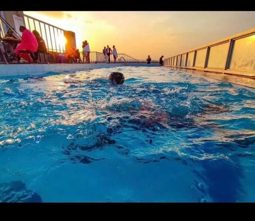 a person swimming in a swimming pool on a cruise ship at Feel Home -One bedroom with swimming pool in Kiambu