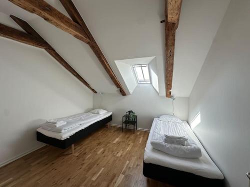 2 camas en una habitación con suelo de madera en Innerstan nya lägenheter Södramurgatan 45b, en Visby