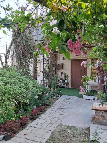 una casa con rosas rosas a un lado. en Dormitories/Hosteller, Giftland Homestay, en Āīzawl