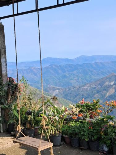 a swing with flowers and plants on a mountain at Dormitories/Hosteller, Giftland Homestay in Āīzawl