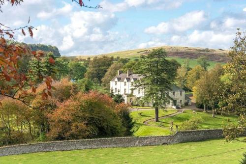 a large white house in the middle of a green field at Carphin House near St Andrews - Sleeps 18 in Fife