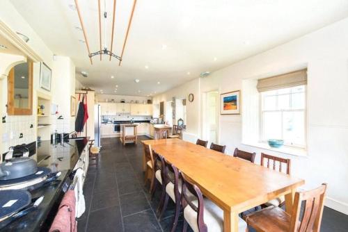une cuisine et une salle à manger avec une table et des chaises en bois dans l'établissement Carphin House near St Andrews - Sleeps 18, à Fife