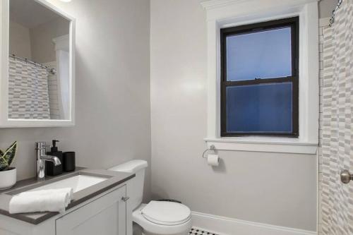 シカゴにある3BR Vibrant Apartment in Hyde Park - Bstone 5310-1の白いバスルーム(トイレ、窓付)