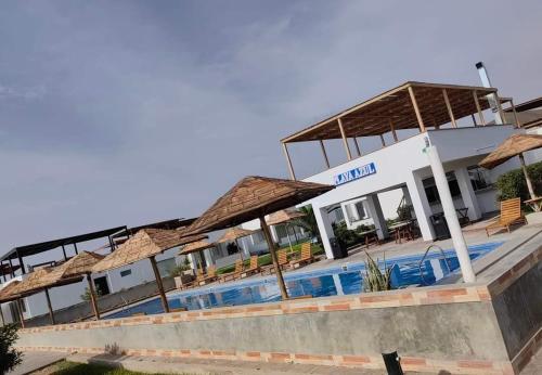 een hotel met een zwembad en parasols bij Casa de estreno en Playa Azul in Cerro Azul
