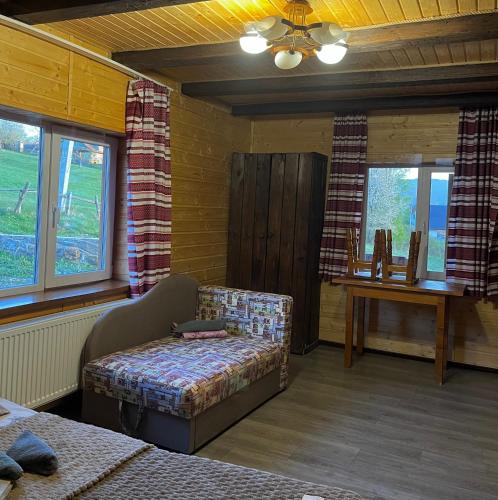 a room with a bed and a couch and a table at Khatky Na Penkakh in Vorokhta