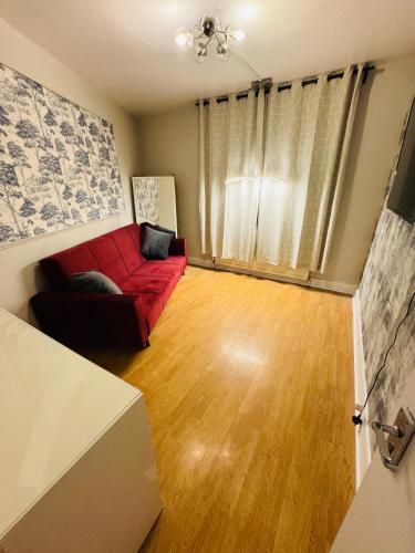倫敦的住宿－Elephant and Castle One Bedroom Apartment，客厅设有红色的沙发和木地板