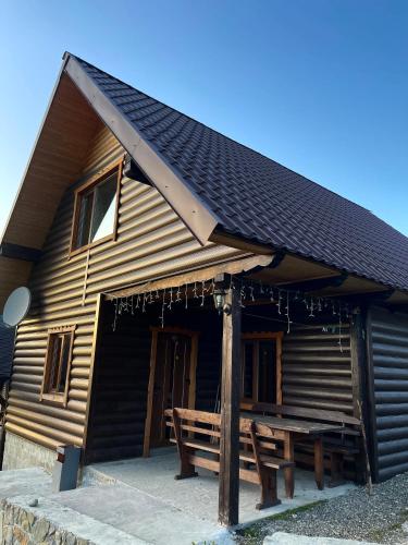 a wooden cabin with a wooden bench in front of it at Khatky Na Penkakh in Vorokhta