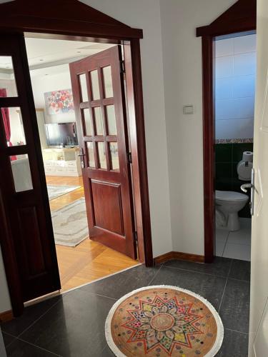 an open door to a bathroom with a toilet and a rug at Airport SKY apartments LUX II in Belgrade