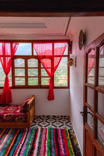 a bedroom with a window and a bed with a rug at Amazigh Family Riad in Imlil