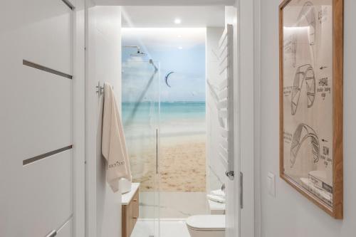 a bathroom with a toilet and a view of the beach at Sanhaus Apartments - Apartament Kite and Surf przy plaży in Sopot