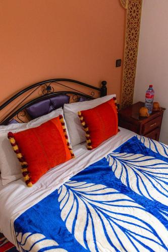 a bed with red and white pillows on it at Amazigh Family Riad in Imlil