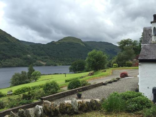 a house with a view of a lake and mountains at Craigruie Farmhouse in Balquhidder